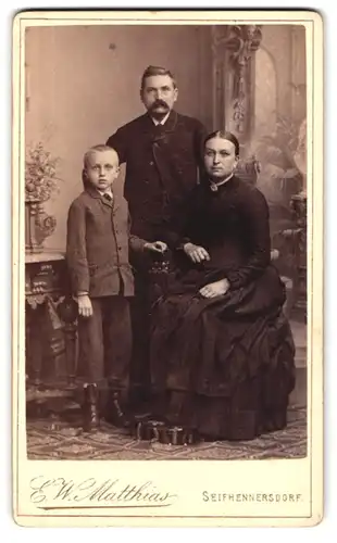 Fotografie E. W. Matthias, Seifhennersdorf, gut gekleidete Familie in vertrauter Pose