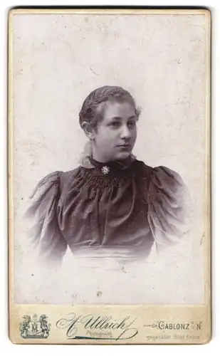 Fotografie A. Ullrich, Gablonz a. N., Portrait junge Frau im Kleid mit Puffärmeln und Marienbrosche
