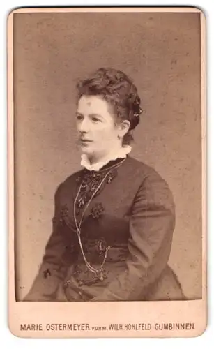 Fotografie Marie Ostermeyer, Gumbinnen, Darkehmer-Strasse 177, Portrait Dame im bestickten Kleid mit Halskette und Locken