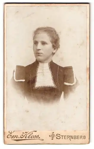 Fotografie Em. Kloss, Sternberg, Breitegasse 13, Portrait Frau im taillierten Kleid mit Locken
