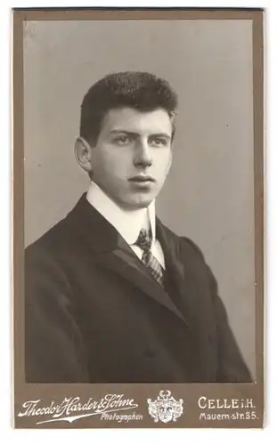 Fotografie Theodor Harder & Söhne, Celle i. H., Mauern-Str. 35, Portrait junger Mann im schwarzen Anzug mit Krawatte
