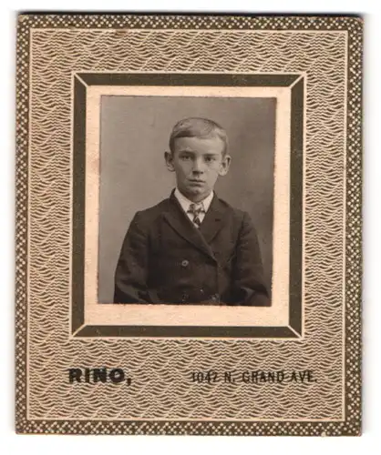 Fotografie Rino, Ort unbekannt, Grand Ave. 1042, Portrait junger Knabe Alfred im Anzug mit Segelohren