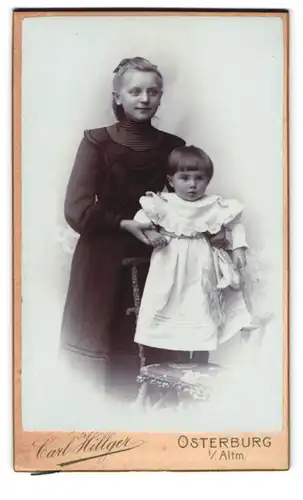 Fotografie Carl Hillger, Osterburg i. Altm., Portrait grosse Schwester im schwarzne Kleid mit kleiner Schwester
