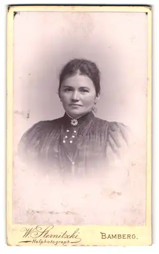 Fotografie W. Sternitzki, Bamberg, Hainstr. 2, Junge Dame mit Blumenbrosche in kariertem Kleid