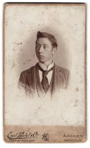 Fotografie Emil Körbel & Co., Aachen, Adalbertstr. 39, Portrait junger Knabe im Anzug mit Schlipt und Tolle