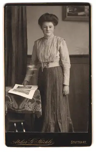 Fotografie atelier G. Stöckle, Stuttgart, Blumenstrasse 19, Portrait Dame im Faltenrock und heller Bluse mit Fotoalbum