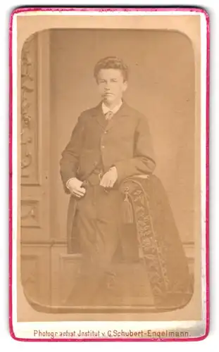 Fotografie G. Schubert-Engelmann, Freiberg, Fischerstr. 48, Bursche im Anzug an Sessel lehnend