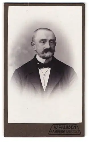 Fotografie W. Paulsen, Hamburg, Bergstr. 3, Portrait Herr im Anzug mit Schnauzbart & Glatze