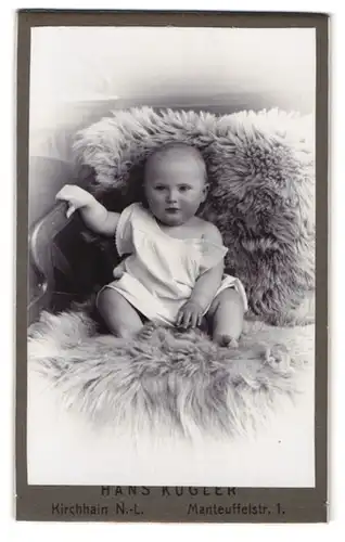 Fotografie Hans Kugler, Kirchhain N. L., Manteuffelstr. 1, Baby auf Felldecke sitzend