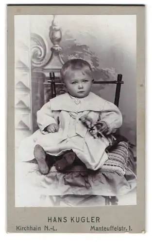 Fotografie Hans Kugler, Kirchhain N. L., Manteuffelstr. 1, Baby mit Spielzeug-Pferd auf Stuhl sitzend