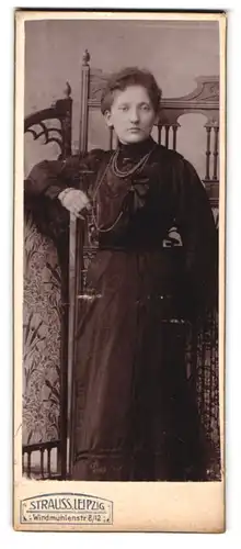 Fotografie Atelier Strauss, Leipzig, Windmühlenstr. 8-12, Dame im schwarzen Kleid posiert am Raumteiler