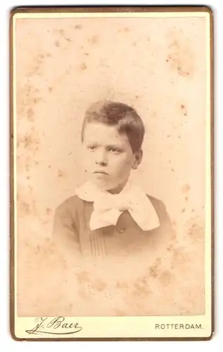 Fotografie J. Baer, Rotterdam, Schiedamsche Singel 55, Portrait genervt blickender Knabe mit Halstuch