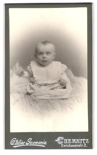 Fotografie Atelier Germania, Chemnitz, Zwickauerstr. 2, Baby mit Latz auf Felldecke sitzend