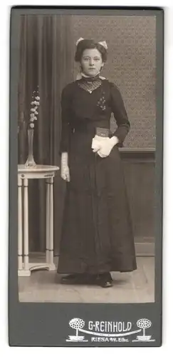 Fotografie G. Reinhold, Riesa a. d. Elbe, Portrait junge Frau im schwarzen Kleid mit Handschuhen