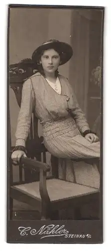 Fotografie C. Nähler, Steinau a. O., Portrait Dame im karierten Kleid mit breitem Hut sitzt auf Stuhllehne