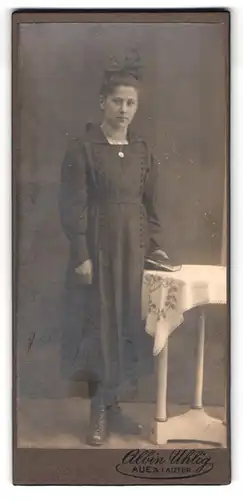 Fotografie Albin Uhlig, Aue i. S., Bahnhofstr. 11, Portrait Dame im schwarzen Kleid mit Haarschleife und Halskette