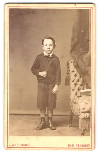 Fotografie L. Wesemann, Bad Rehburg, Portrait junger Knabe im Anzug mit dreiviertel Hosen und Fliege