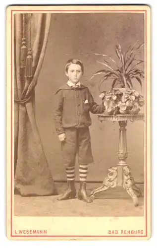 Fotografie L. Wesemann, Bad Rehburg, Portrait Knabe im Anzug mit gestreiften Socken, dreiviertel Hosen
