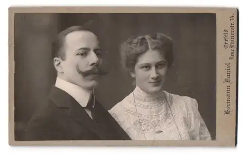 Fotografie Hermann Daniel, Crefeld, Neue Linnenstr. 74, Portrait Mann mit Kaiser Wilhlem Bart und Frau im Rüschenkleid