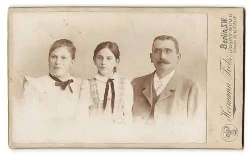 Fotografie Hermann Tietz, Berlin, Leipziger-Str. 46-49, Portrait Mutter und Vater mit Tochter im Hosenträgerkleid