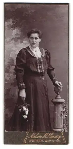 Fotografie Atelier M. Radig, Wurzen, Wettinerstr. 7, Portrait Dame im dunklen Kleid mit Halskette vor Studiokulisse
