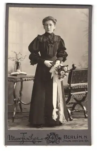 Fotografie Max Fischer, Berlin, Invalidenstr. 164, Portrait junge Frau im schwarzen Kleid mit Blumestrauss in der Hand