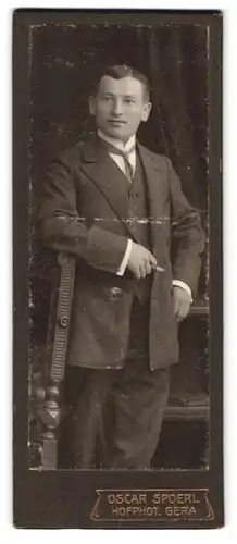 Fotografie Oscar Spoerl, Gera, Portrait Herr im Anzug mit gehäkeltem Schlips und Zigarre