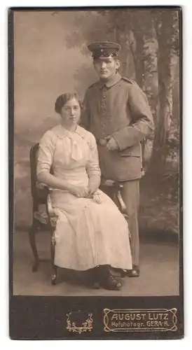 Fotografie August Lutz, Gera-R., Portrait Soldat in Uniform mit Schirmmütze und Frau