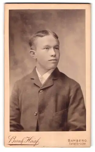 Fotografie Bernh. Haaf, Bamberg, Kettenbrücke, Portrait junger Mann im Anzug mit markantem Kinn