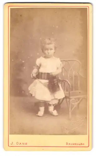 Fotografie J. Ganz, Bruxelles, Rue de l`Ecuyer 38, Portrait kleines Mädchen im wessen Kleid mit Locken