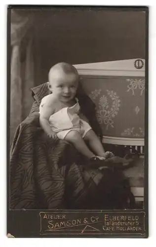 Fotografie Samson & Co., Elberfeld, Isländerufer 5, Portrait Kleinkind im weissen Leibchen grinst in die Kamera