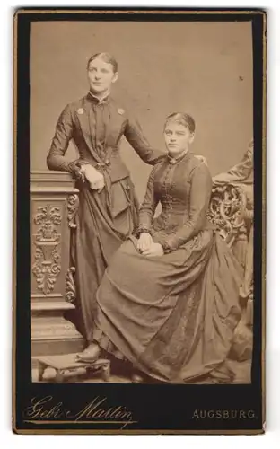Fotografie Gebr. Martin, Augsburg, Bahnhofstr., Portrait zwei Damen in dunklen Kleidern mit Broschen