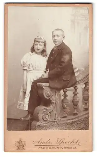 Fotografie Andr. Specht, Flensburg, Holm 12, Knabe im Anzug auf Brüstung sitzend, Mädchen im weissen Kleid