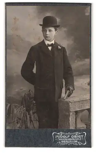 Fotografie Rudolf Obigt, Berlin, Reinickendorferstr. 2, Knabe im Anzug mit Hut & Bibel nach der Kommunion