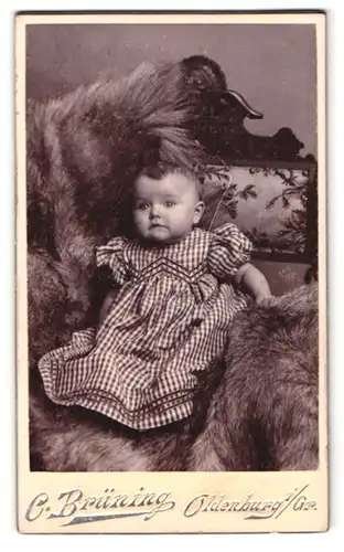 Fotografie C. Brüning, Oldenburg i. Gr., Donnerschweerstr. 7, Baby im Kleid mit Karomuster