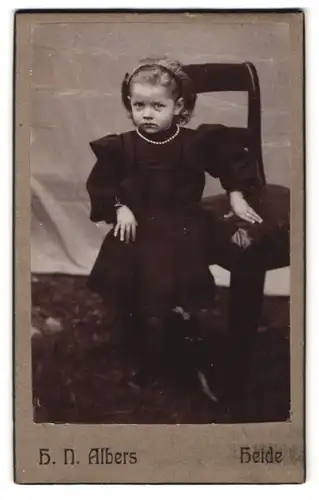 Fotografie H.N. Albers, Heide, Mädchen mit Haarreif und Perlenkette im schwarzen Kleid