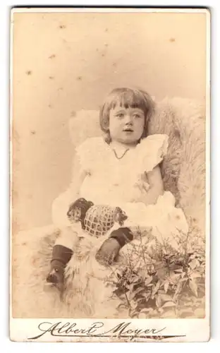 Fotografie Albert Meyer, Berlin, Alexanderstr. 45, junges Mädchen im weissen Kleid mit Perlenkette auf Fell