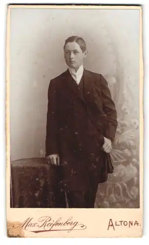 Fotografie Max Reifenberg, Altona, Ecke Bachstrasse und Reichenstrasse, Junger Mann im Anzug neben einem Beistelltisch