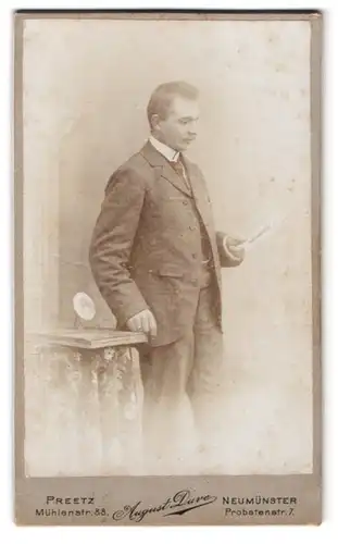 Fotografie August Duve, Preetz, Mühlenstr. 88, Mann im Anzug mit Blick auf die Zeitschrift