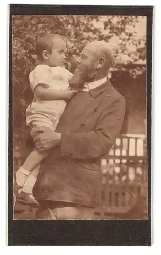 Fotografie unbekannter Fotograf und Ort, Portrait bürgerlicher Herr mit Kind auf dem Arm
