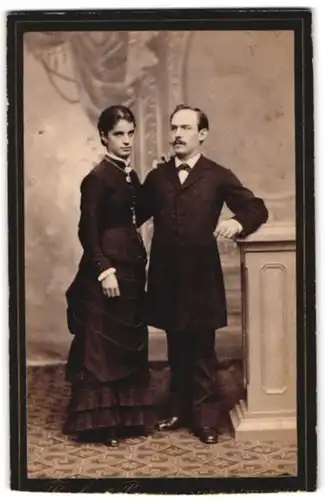 Fotografie Bacher & Person, Lahr i. B., Kaiserstrasse 19, Portrait Frau in gerüschtem Kleid und Mann im Anzug