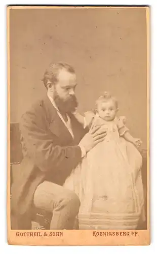 Fotografie Gottheil & Sohn, Königsberg i. P., Münzstr. 6, Vater mit Vollbart hält baby im Taufkleid