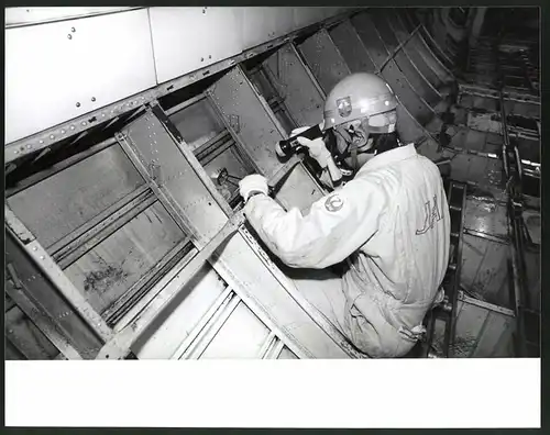 Fotografie Flugzeug-Mechaniker der JAL Japan Air Lines untersucht Flugzeug-Komponente