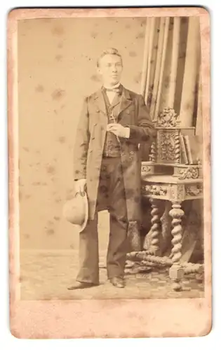 Fotografie H. Hirsch, Berlin, Christinenstr. 36, Junger Mann im Anzug mit Hut in der Hand