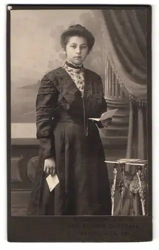 Fotografie R. Ochernal & Sohn, Marienberg / Sachsen, hübsche Dame im dunklen Kleid mit Zettel in der Hand