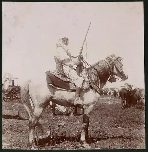 Fotografie Beduinenführer mit Gewehr und Prunksattel zu Pferd