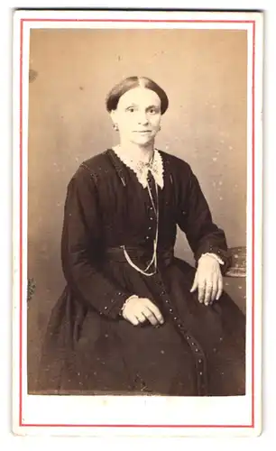 Fotografie unbekannter Fotograf und Ort, Dame in schwarzem Kleid mit weissem Kragen und Ohrringen