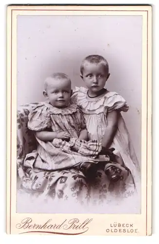 Fotografie Bernhard Prill, Lübeck, Breitestrasse 97, Portrait zwei kleine Mädchen in Kleidern mit Puppe