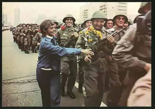 Fotografie Berlin, Tag der Kampfgruppen, junge Frau überreicht Blumenstrauss an einen Soldat in der Parade