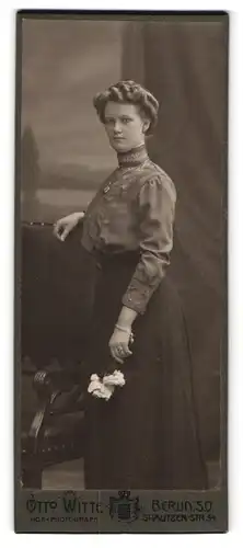 Fotografie Otto Witte, Berlin, Skalitzer-Str. 54, Junge Dame in mit Stickereien verzierter Bluse hält Blumen